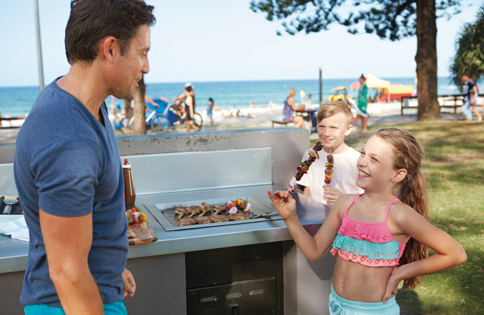 Family using free beach bbqs