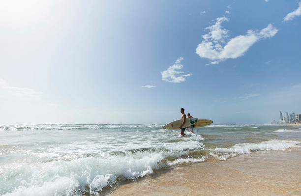 Surfers running into water